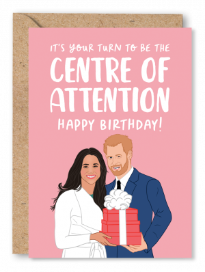 A pink Birthday card featuring an illustration of Prince Harry and Meghan Markle holding a gift wrapped present alongside white text reading ‘It’s your turn to be the centre of attention, Happy Birthday!’