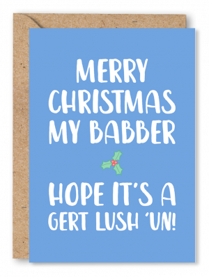 A light blue Christmas card with an illustration of holly alongside white text reading ‘Merry Christmas my Babber! Hope it’s a Gert lush ‘un’