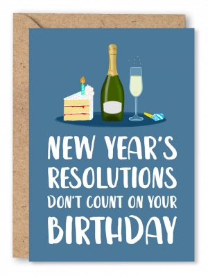 A navy blue birthday card featuring an illustration of a bottle of Prosecco, a glass of Prosecco, a party blower and a slice of cake with a candle in the top. White text along the bottom reads ‘New Year’s resolutions don’t count on your Birthday’