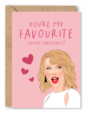 A pink anniversary card featuring an illustration of Taylor Swift alongside 3 hearts. Red text at the top of the card reads ‘You’re my favourite (after cardigans)’