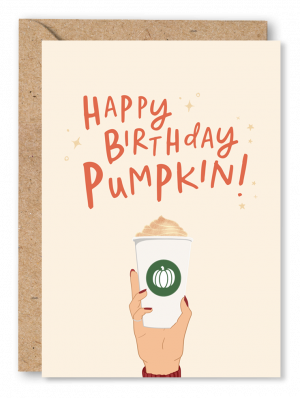 A October Birthday card featuring an illustration of a hand holding a Pumpkin Spice Latte on a peach background. Orange text above reads ‘Happy Birthday Pumpkin’